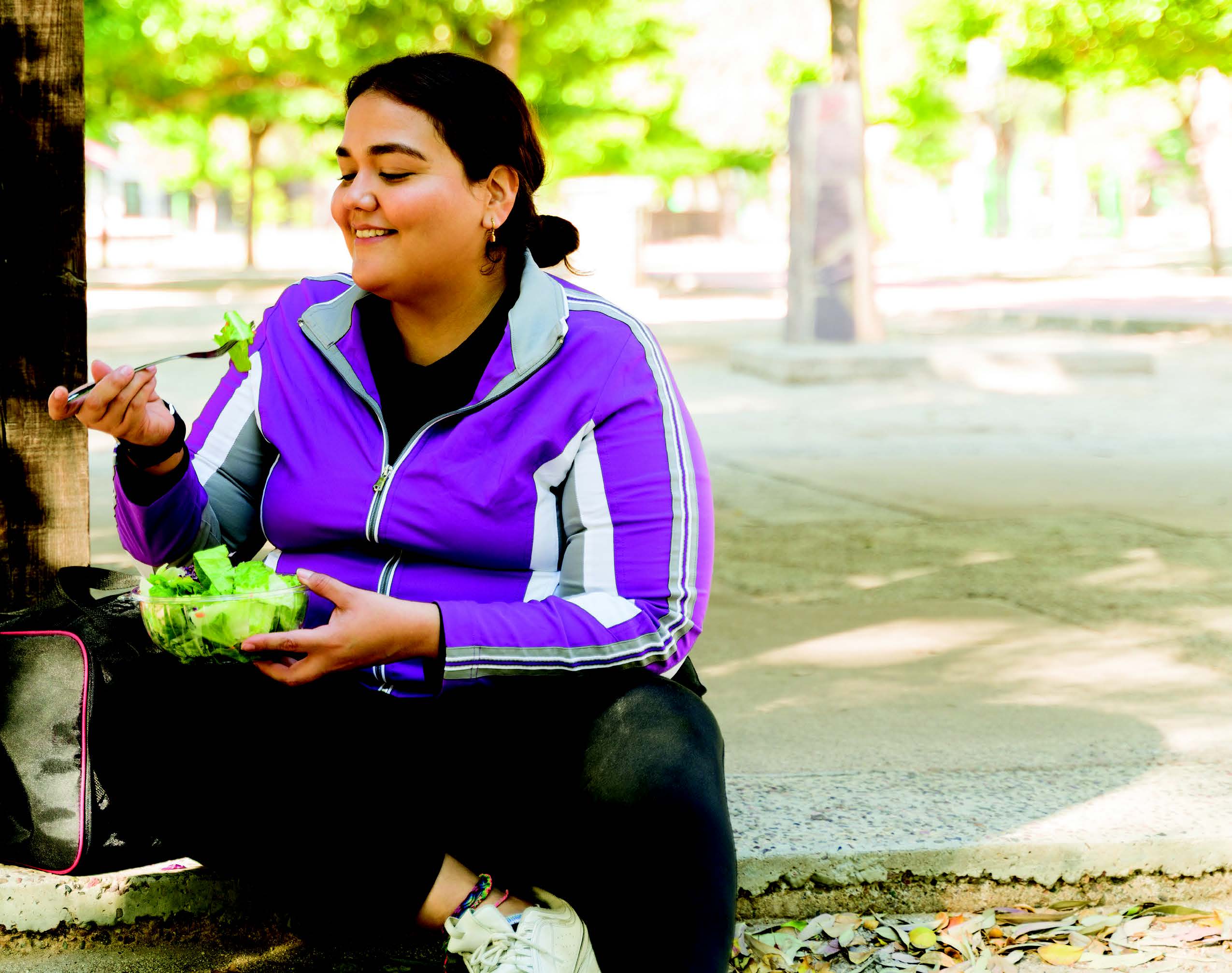 woman eating a salad outside