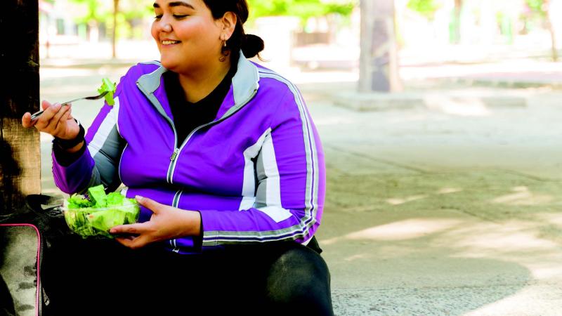woman eating a salad outside